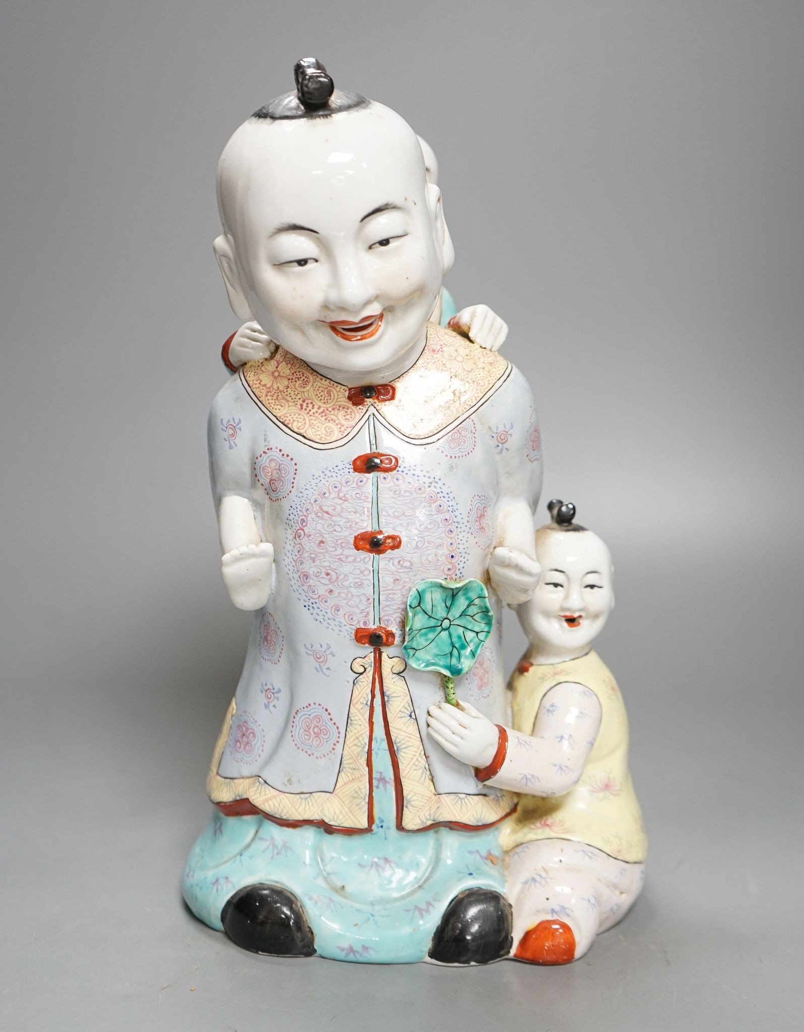 A large Chinese enamelled porcelain boys group, 31cm